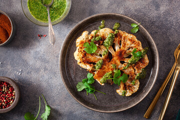 cauliflower steaks with herb sauce and spice. plant based meat substitute