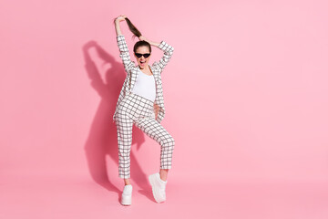 Full size portrait of pretty lady arm hold hair tail open mouth white checkered clothing isolated on pink color background