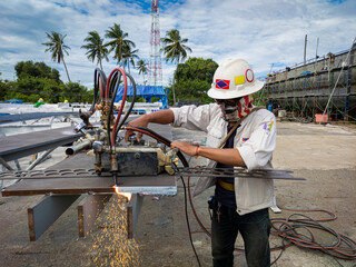 Workers are using gas cutting machines to cutting steel plates at industrial factory.