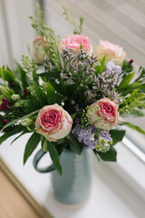 mid side angled view of bouquet blue vase handle ceramic of rose flowers bunch pink green purple macro close up vertical shallow