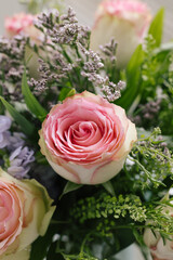 tight angled view of bouquet of rose flowers bunch pink green purple macro close up vertical focussed
