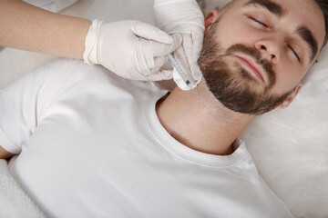Fototapeta na wymiar Cropped shot of a beautician injecting facial filler into neck wrinkles of a male client