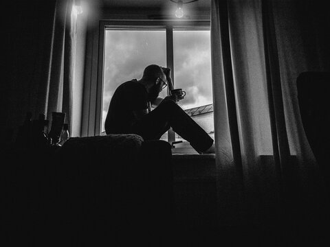 A lonesome man in sittning in a window