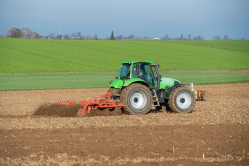Obraz premium Traktor mit Egge auf einem Acker