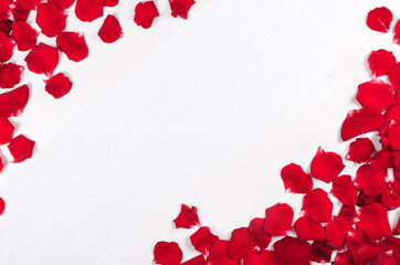 Background with red rose petals on white wooden table