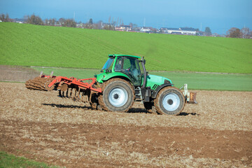 Fototapeta premium Traktor mit Egge auf einem Acker