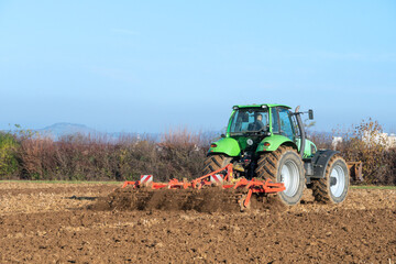 Traktor mit Egge auf einem Acker