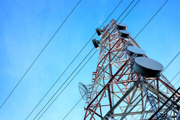Communication pillar and electric wires on blue sky background. Telecommunication and internet provider equipment. Tall communication tower with many antennas. 5G wifi transmission tower