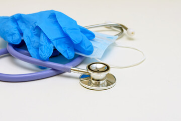 Stethoscope, medical mask and gloves on a white background. Close up.