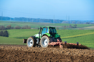 Traktor mit Egge auf einem Acker