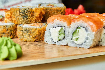Set of various sushi rolls on a board. Close-up, selective focus