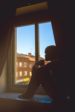A lonesome man in sittning in a window
