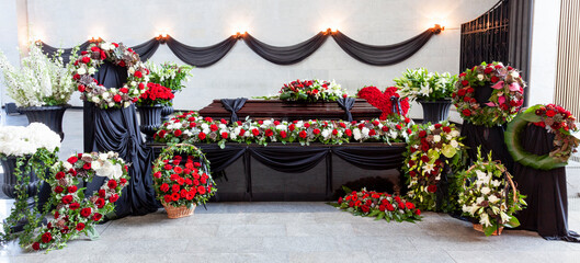 The coffin is decorated with various flowers. A beautiful funeral ceremony. Panorama format. - obrazy, fototapety, plakaty