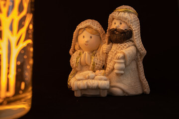 Representation of a Christmas nativity scene with the figures of baby Jesus, Mary and Joseph on a black background. Christmas concept.