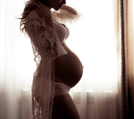 Beautiful silhouette of a pregnant woman with a belly in the ninth month
