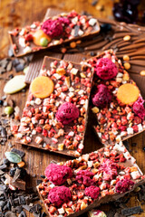 leckere schokoladentafel mit himbeeren, mandeln und nüssen verziert