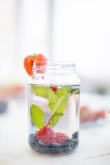 Strawberry on the edge of a mint and berries drink