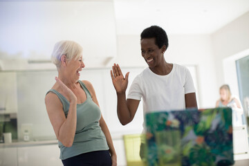 Happy senior women friends high fiving after online workout