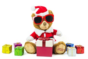 A teddy bear doll wearing santa set and glasses with many colorful gift boxes isolated on white background,Christmas day and New Year's gifts