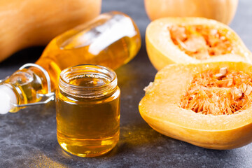 Pumpkin seed oil in a glass jar on a dark table. Change traditional oil
