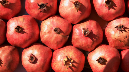 Pile of red ripe pomegranate fruits at market stall. Heap of fresh fruits at street market on a...