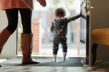 Mother and baby daughter at open front door