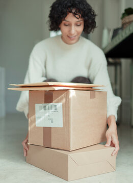 Woman receiving packages stacked on floor