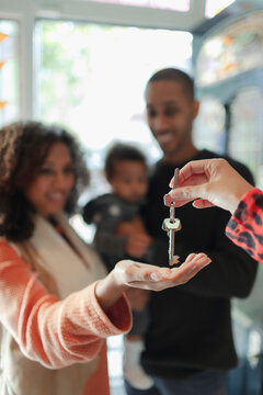 Family receiving new house keys from realtor