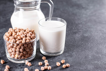 Dairy-free milk. Chickpea nut scattered on the surface in a glass jar and milk in a mug on a table. Lactose free, copy space