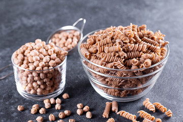 Dried chickpeas and whole wheat pasta in a bowl on the table. Healthy produc