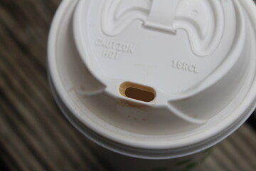 Looking down on a to go coffee drink with coffee stains on the mouth of the lid.