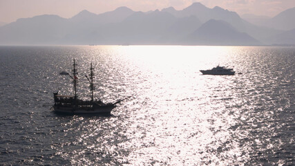 Boats floating in the sea on a summer day. Foggy mountains in the background. Travel to Turkey.
