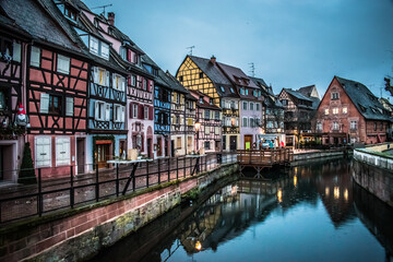 Fototapeta na wymiar Reflections in the river of the colored houses of Colmar at dawn at Christmas