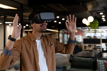 Mixed race businessman wearing virtual reality headset in creative office
