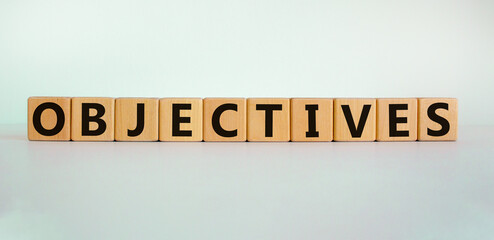 Objectives symbol. Word 'objectives' written on wooden blocks. Business and objectives concept. Copy space. Beautiful white background.