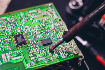 Technician repair electronic circuit board with soldering iron and tin wire.  Repair of electronic...