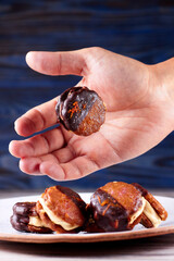 Hand catches flying little marshmallow cookies on a blue wooden background