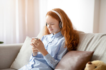 Girl wearing headphones enjoying music with phone