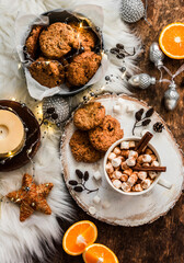 Christmas mood still life. Dried cranberries, walnuts, oatmeal cookies, hot chocolate, christmas decorations on a wooden background, top view