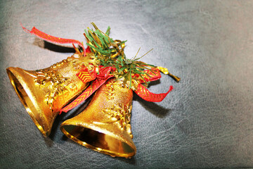 Golden bells with red ribbon on gray background