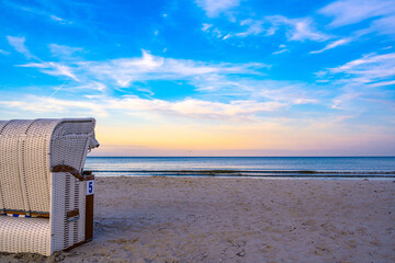 Juliusruh, Germany - 9. September 2020: Quiet sunset at the beach of Juliusruh on the island of Ruegen with beach chairs on the sandy beach with the Baltic Sea in the background