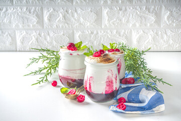 Cranberry layered Dessert breakfast in small jars for Christmas morning. Homemade baked Cranberry meringue dessert, with fresh cranberries and mint, copy space