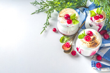 Cranberry layered Dessert breakfast in small jars for Christmas morning. Homemade baked Cranberry meringue dessert, with fresh cranberries and mint, copy space