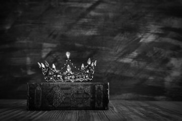 low key image of beautiful queen/king crown on old book. vintage filtered. fantasy medieval period....