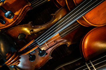 Close-up of a pile of violins on a diagonal.