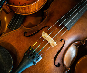 Close-up of a pile of violins on a diagonal.