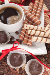 Cup of morning coffee with chocolates and waffles