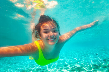Portrait of happy teen smiling positive girl with screaming open mouth and spread hands floating...