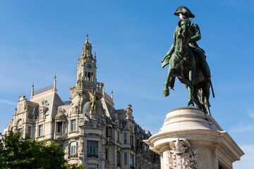 Obraz premium Man riding a horse with a seagull perched in its head. Antique building in the background. Statue of D. Pedro IV. Blue sky. Porto