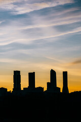 Fototapeta na wymiar Cuatro Torres Business Area Madrid skyline at sunset with high contrast in vertical